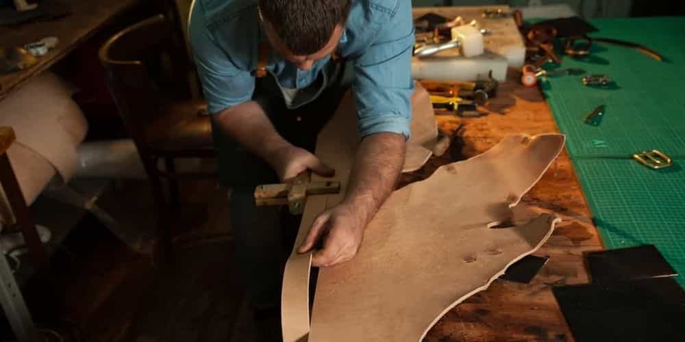Leatherworker cutting leather